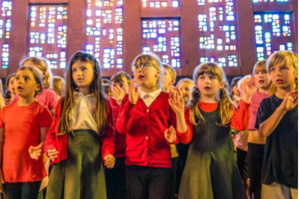 Primary school pupils sing together in a choir