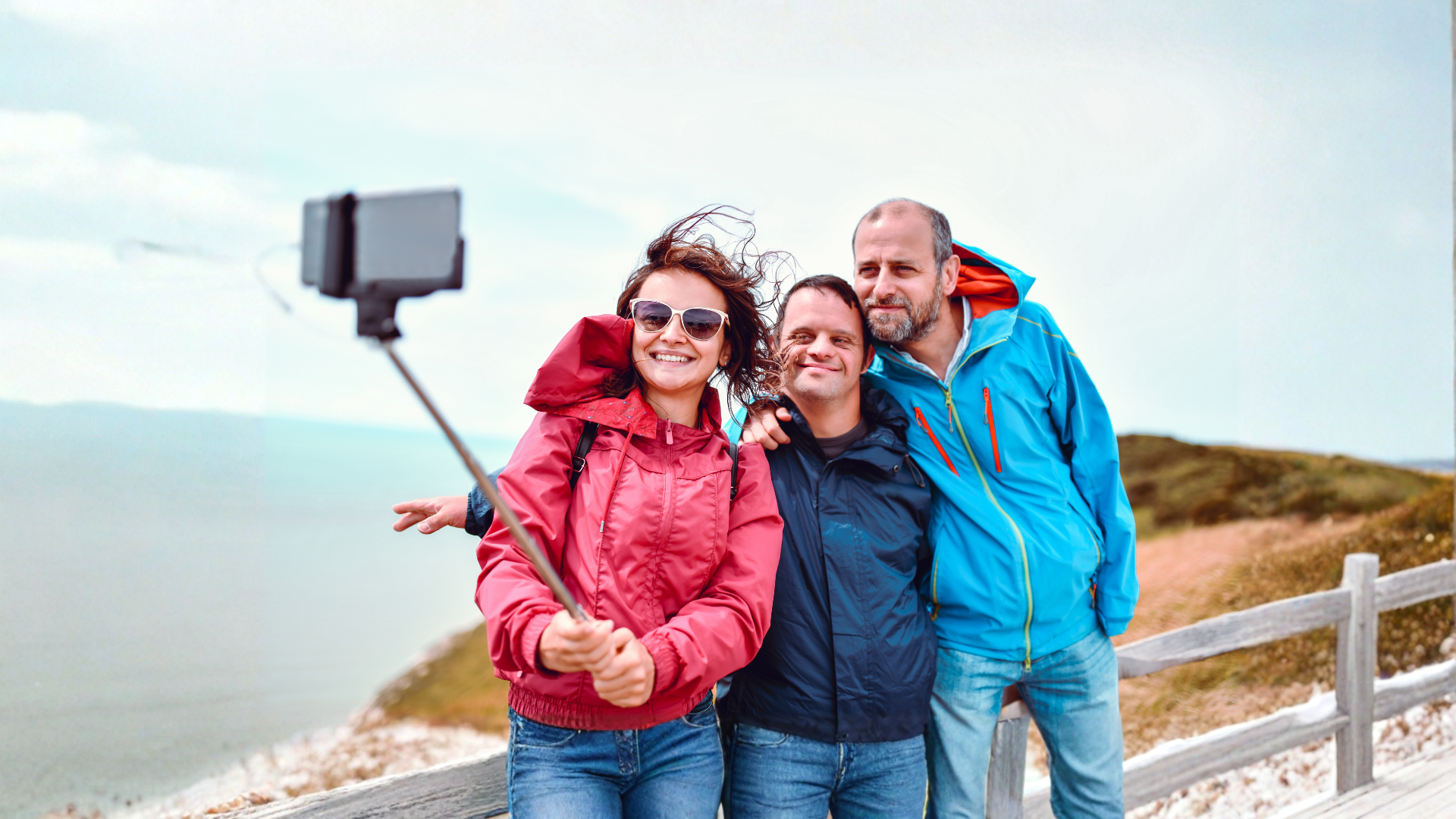 picture of three people taking a photograph of themselves at the beach