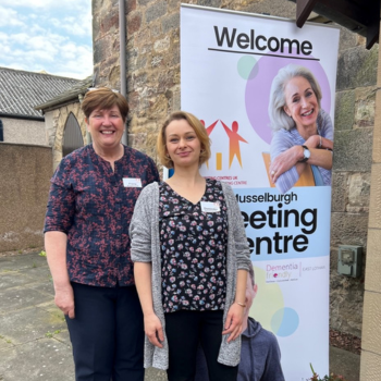 Two women standing outside Meeting Centre