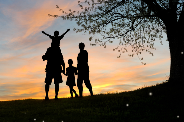 family silhouetted at sunset