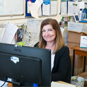 Woman sitting at desk smiling