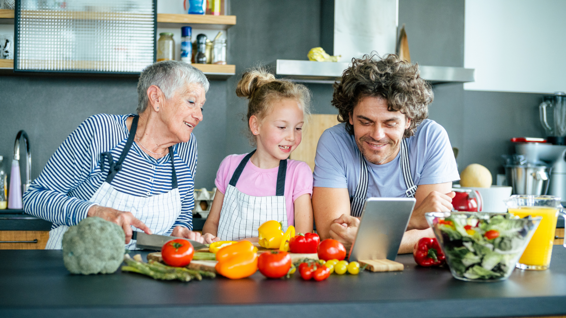 family group preparing a meal together in a kitchen using fresh vegetables
