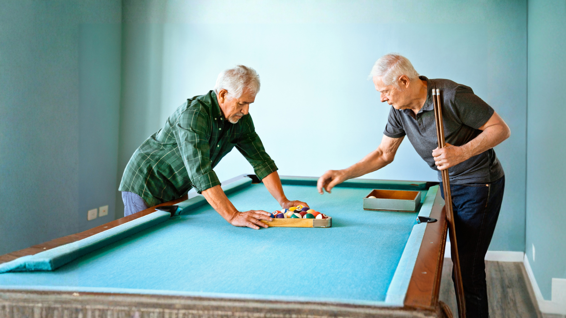 two men setting up a snooker table