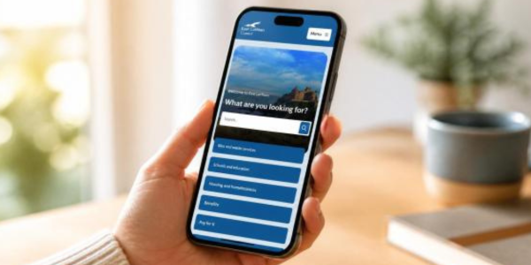 Someone holding a smartphone with the new council website on screen