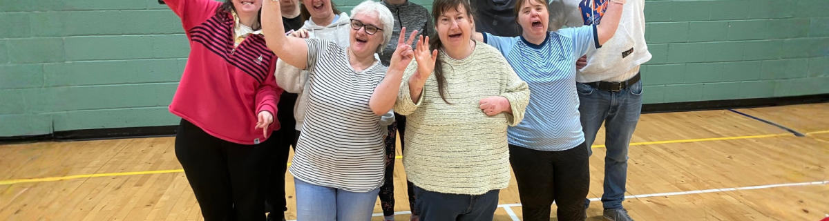 a group of adults with learning disabilities smiling and cheering