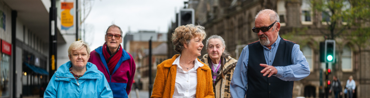 Group of older adults walking the high street