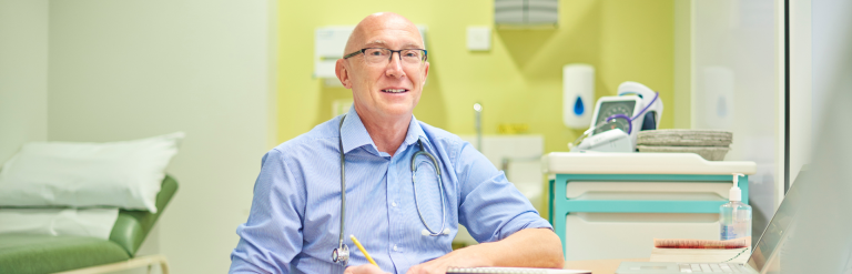 doctor sitting at desk in patient consultation room