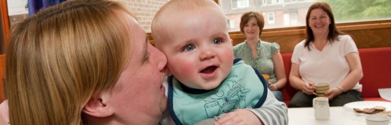 mother holding a smiley baby